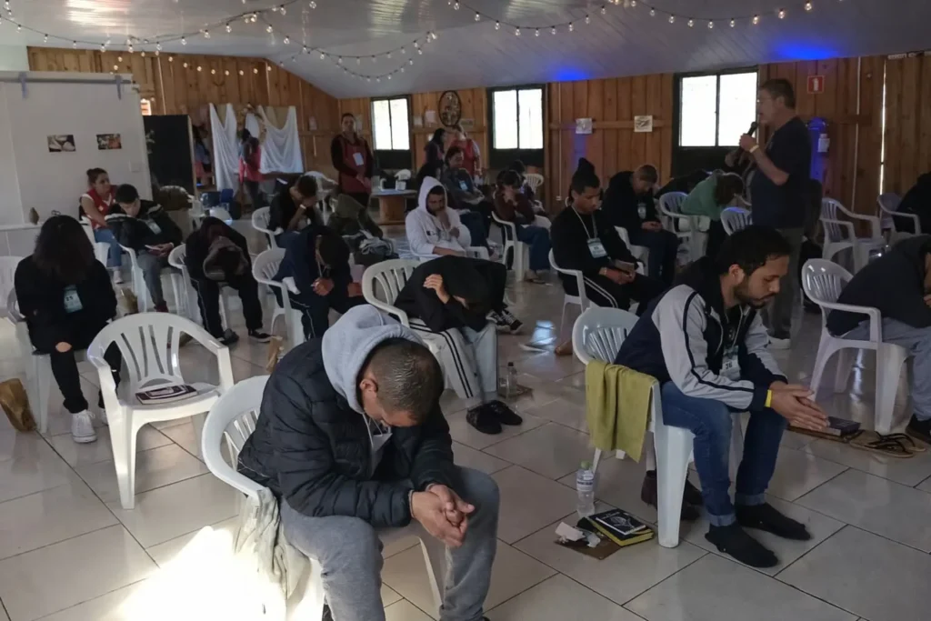 A imagem mostra um momento de oração no Encontro com Deus da Igreja Adore, marcado por reflexão, entrega espiritual e comunhão com Deus.