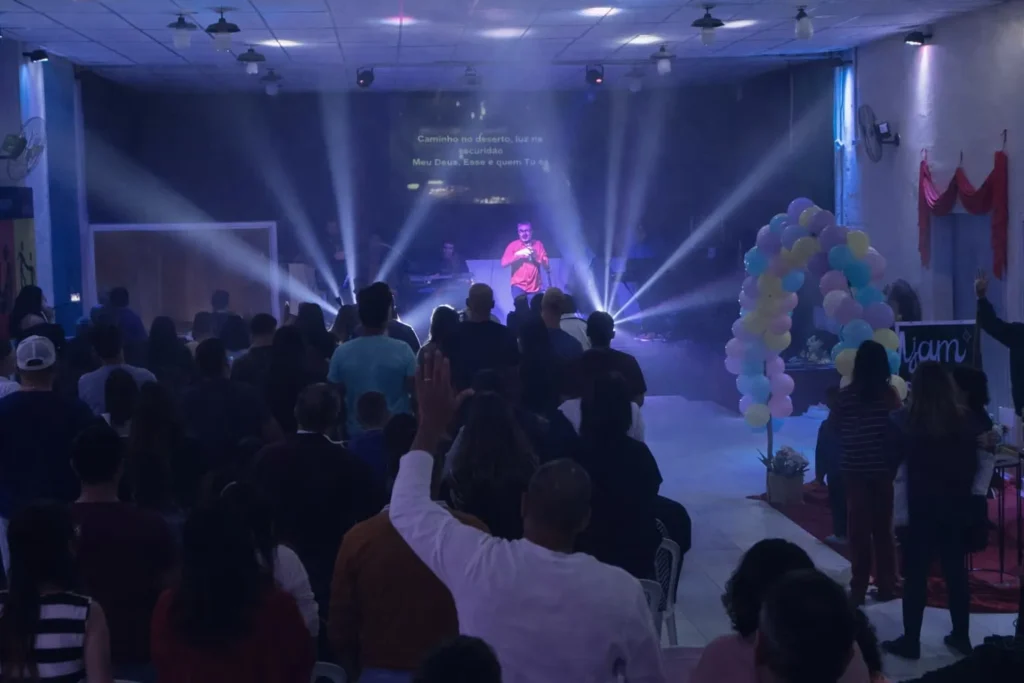 A imagem mostra a celebração do aniversário da Igreja Adore, com a igreja reunida em um culto especial marcado por adoração, alegria e comunhão.